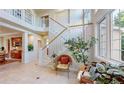 Bright entryway with high ceilings, staircase, tiled floor, and large windows that offer plenty of natural light at 5398 S Jay Dr, Littleton, CO 80123