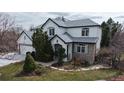 Charming two-story home with stone accents, a well-maintained lawn, and mature trees in a lovely landscaped front yard at 5398 S Jay Dr, Littleton, CO 80123