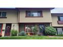 Charming townhome exterior with well-maintained lawn, colorful garden, and covered entryway at 442 S Carr St, Lakewood, CO 80226