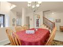 Spacious dining room featuring tile flooring, access to the staircase, and neutral colored walls at 1533 Bellflower Dr, Brighton, CO 80601