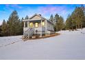 Cozy cabin with covered porch, gray siding, and charming curb appeal set in a snowy landscape at 1056 County Road 65, Evergreen, CO 80439