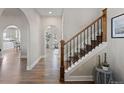 Open-concept hallway with hardwood floors, arched entryways, and access to living spaces at 7071 S Gibraltar Way, Centennial, CO 80016