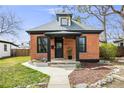 Charming brick home featuring a cozy front porch and manicured lawn at 4673 Bryant St, Denver, CO 80211