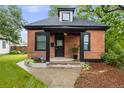 View of brick home with a black front porch entrance and well-manicured lawn at 4673 Bryant St, Denver, CO 80211
