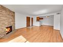 Inviting living room with hardwood floors, stone fireplace, and open access to the kitchen at 420 Zang St # 108, Lakewood, CO 80228