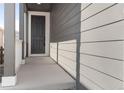 Inviting gray front porch featuring a dark front door and stylish siding at 16423 Mountain Flax Dr, Monument, CO 80132