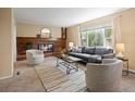 Inviting living room features a brick fireplace, plush seating, and large picture window at 5808 E Hinsdale Pl, Centennial, CO 80112
