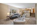 Comfortable living room with neutral tones, large window, and easy access to the kitchen at 5808 E Hinsdale Pl, Centennial, CO 80112