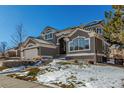 Two-story home with a three car garage and snowy front yard at 9647 Colinade Dr, Lone Tree, CO 80124