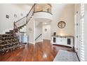 Stunning foyer with soaring ceilings, hardwood floors, curved staircase and statement console table at 11938 S Meander Way, Parker, CO 80138