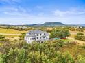 An elevated view shows a house with beautiful landscaping, a pool and mountain views at 1635 Sharps Ct, Castle Rock, CO 80109