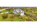 An elevated view shows a house with beautiful landscaping on a green lawn at 1635 Sharps Ct, Castle Rock, CO 80109