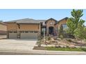 Inviting home with a stone and stucco exterior, lush front yard landscaping, and a spacious three-car garage at 15637 Deer Mountain Cir, Broomfield, CO 80023