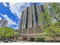 Tall condo building with beautiful blue skies and trees surrounding the property at 1777 Larimer St # 902, Denver, CO 80202