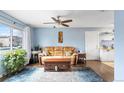 Bright living room boasts a tan leather sofa, ceiling fan, and large window at 10405 W 107Th Pl, Broomfield, CO 80021