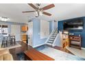 Open-concept living area featuring a TV, stairs, modern lighting, and seamless flow to the kitchen at 10405 W 107Th Pl, Broomfield, CO 80021