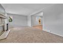 Bright living room with neutral carpet, stone fireplace, and open floor plan at 3463 W Bowles Ave, Littleton, CO 80123