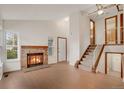 Inviting living room showcasing a cozy fireplace, neutral walls, and staircase to the upper level at 10450 W 81St Pl, Arvada, CO 80005