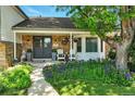 Inviting front porch with chairs and beautiful landscaping, enhancing the home's curb appeal at 6979 E Fremont Ave, Centennial, CO 80112
