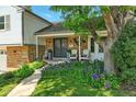 Inviting front porch with chairs and beautiful landscaping, enhancing the home's curb appeal at 6979 E Fremont Ave, Centennial, CO 80112
