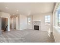 Spacious living room featuring a stone fireplace, plush carpeting, and access to a hallway with barn doors at 2387 Bristol St, Superior, CO 80027