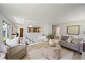 Open living room with view into kitchen, light wood floors, and comfortable seating at 1018 Kelly Pl, Longmont, CO 80501