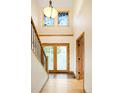 Inviting foyer with high ceilings, frosted glass doors, hardwood floors and natural wood trim at 4398 W Lake S Cir, Littleton, CO 80123