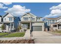 Inviting two-story home featuring a covered porch, a two-car garage, and a well-maintained lawn at 21127 E 62Nd Dr, Aurora, CO 80019