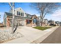 Charming home with a well-maintained front yard and a two-car garage in a suburban neighborhood at 10055 Hughes Pl, Highlands Ranch, CO 80126