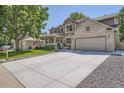 Two-story house with a long concrete driveway and attractive landscaping and trees at 1607 Garnet St, Broomfield, CO 80020