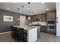 Modern kitchen with granite island, stainless steel appliances, and dark wood cabinets at 6211 Leilani Ln, Castle Rock, CO 80108