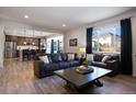 Open living room with a view into the kitchen, featuring two leather couches and a coffee table at 6211 Leilani Ln, Castle Rock, CO 80108