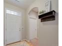 Welcoming entryway with white door, neutral walls, shelf with decorations, and hardwood floors at 12340 Syracuse St, Thornton, CO 80602
