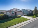 Aesthetic single-Gathering home exhibiting a manicured lawn and wide driveway on a sunny day at 12340 Syracuse St, Thornton, CO 80602