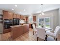 Modern kitchen and dining area with wood cabinets, stainless steel appliances, and hardwood flooring at 12340 Syracuse St, Thornton, CO 80602
