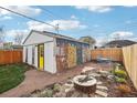 Backyard featuring a stone patio, fire pit, and garage with a mural at 4883 Perry St, Denver, CO 80212
