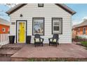 Inviting front porch with comfortable seating and a bright yellow door at 4883 Perry St, Denver, CO 80212