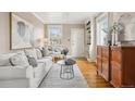 Comfortable living room features hardwood floors, a white sofa, and built-in shelving, providing a relaxing atmosphere at 4883 Perry St, Denver, CO 80212