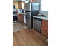 Functional kitchen featuring stainless steel appliances, a mix of wooden and tile flooring, and granite countertops at 1925 Joliet St, Aurora, CO 80010