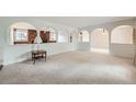 Spacious living area with neutral carpet and distinctive architectural archways at 2056 S Newark Way, Aurora, CO 80014