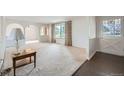 Bright living room featuring neutral carpet, large windows, and arched doorways at 2056 S Newark Way, Aurora, CO 80014