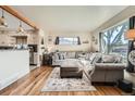 Bright living room featuring hardwood floors, an oversized window, and views into the kitchen at 7060 Avrum Dr, Denver, CO 80221