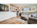 Inviting living room with hardwood floors, a comfortable sofa, and a pass-through to the kitchen at 7060 Avrum Dr, Denver, CO 80221