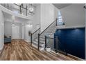 Staircase with stylish railing, wood steps and a distinctive dark blue accent wall at 10624 Ladera Pt, Lone Tree, CO 80124