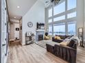 Spacious living room boasting a large window, high ceilings, a cozy fireplace, and a stylish sectional sofa at 938 Larkspur Ln, Louisville, CO 80027