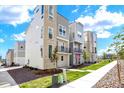 Row of modern townhomes with stone and siding exterior accents and small balconies at 11205 W 53Rd Ln, Arvada, CO 80002