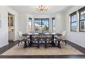 Bright dining room with large windows, modern chandelier, and stylish dark wood furniture at 1280 Gentle Rain Dr, Castle Rock, CO 80109