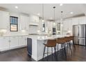 Modern kitchen with white cabinets, stainless steel appliances, and a large center island at 1280 Gentle Rain Dr, Castle Rock, CO 80109
