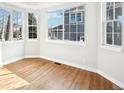 Bright bedroom featuring large windows, beautiful wood floors and white walls at 5352 Brookside Dr, Broomfield, CO 80020