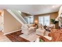 Inviting living room with hardwood floors, a cozy seating area, a stairway, and natural light filling the space at 11605 E Cornell Cir, Aurora, CO 80014